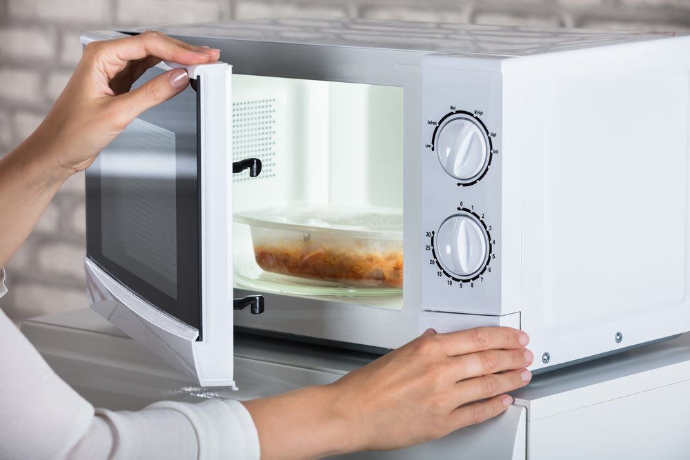 A woman using a microwave